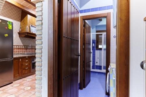 a kitchen with a wooden door and a refrigerator at La Acacia in Martos