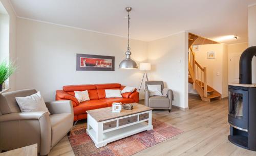 a living room with an orange couch and a table at Seeteufel in Zingst
