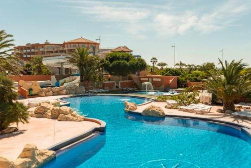 - une piscine d'eau bleue dans un complexe dans l'établissement Le Lagon Rose nice bungalow Camping SIBLU le Mar Estang Canet-en-Roussillon, 2 rooms, 2 bathrooms, 2 TV, free WIFI, sheets & towels included, beach at 5 mn walk, à Canet