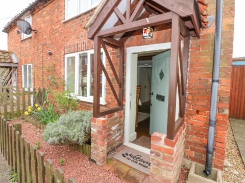 a brick house with an awning over the door at Easter Cottage in Dersingham