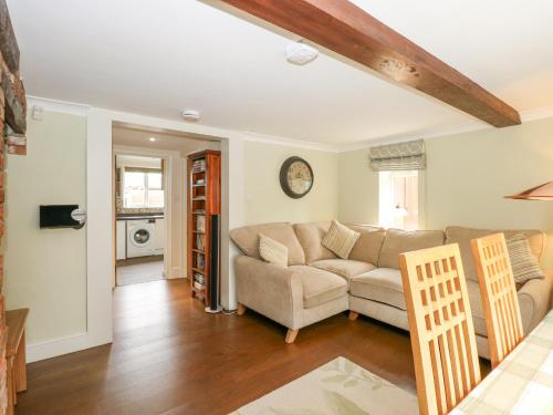 a living room with a couch and a table at Easter Cottage in Dersingham