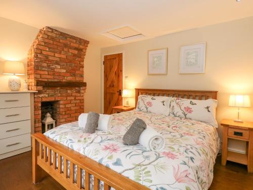una camera da letto con un letto e un camino di Easter Cottage a Dersingham