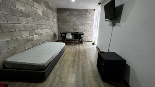a room with a bed and a table in it at Bonito Departamento en el Centro de Guadalajara in Guadalajara