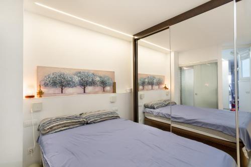 Un dormitorio con dos camas y un espejo. en flat Belvedere las canteras beach, en Las Palmas de Gran Canaria