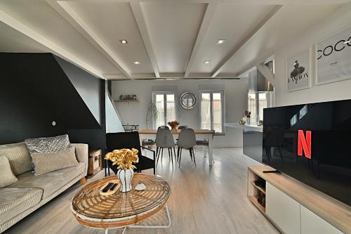 un salon avec un canapé et une table dans l'établissement Précieux - Parking Gratuit, Climatisation, Tv 4K, Fibre, Terrasse, Entièrement Rénové, à Tasdon