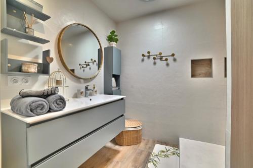 une salle de bain avec un lavabo et un miroir dans l'établissement Précieux - Parking Gratuit, Climatisation, Tv 4K, Fibre, Terrasse, Entièrement Rénové, à Tasdon