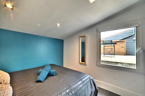 une chambre avec un lit aux murs bleus et une fenêtre dans l'établissement Précieux - Parking Gratuit, Climatisation, Tv 4K, Fibre, Terrasse, Entièrement Rénové, à Tasdon