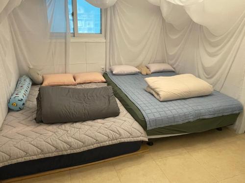 2 łóżka z poduszkami w sypialni w obiekcie Holiday Home near Dongdaemun Myeongdong w Seulu