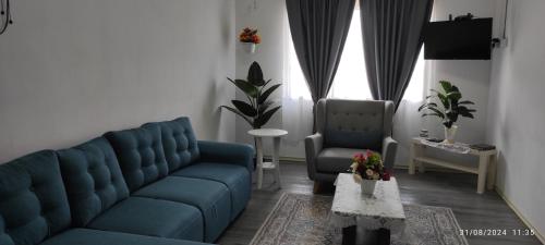 a living room with a blue couch and two chairs at Homestay Mak Serting Tengah in Batu Kikir