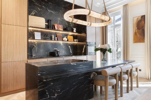 une cuisine avec un comptoir noir et un évier dans l'établissement TheLander - Serviced Apartment in Champs Elysées, à Paris