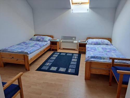 a room with three beds and a rug at Penzión Jana in Zborov