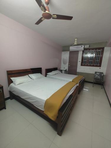 a bedroom with a bed with a ceiling fan at JP Residency, near to Isha, Adhiyogi & Karunya in Alāndurai