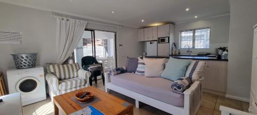 a living room with a couch and a table at Pearly Dunes in Pearly Beach