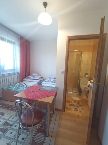 a room with a table and a bed and a bathroom at Pokoje u Zajdy in Zawoja