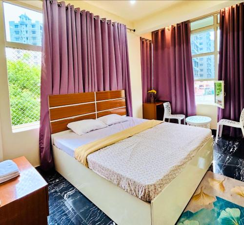 a bedroom with a bed with purple curtains at Himaksh Homestay in Varanasi