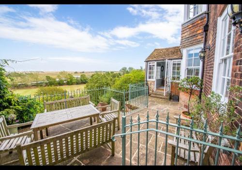 a patio with two benches and a table on a house at Benson House - Rye Town Centre, East Sussex in Rye
