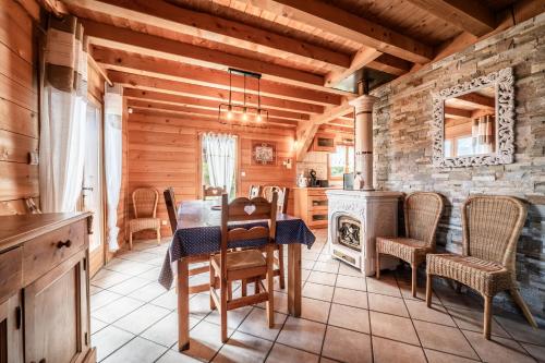 une cuisine avec une table, des chaises et une cuisinière dans l'établissement Chalet familial - Le Laquis, à Morillon