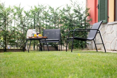 two chairs and a table in the grass at Agriturismo Ca' del Clat in Bagnolo Piemonte