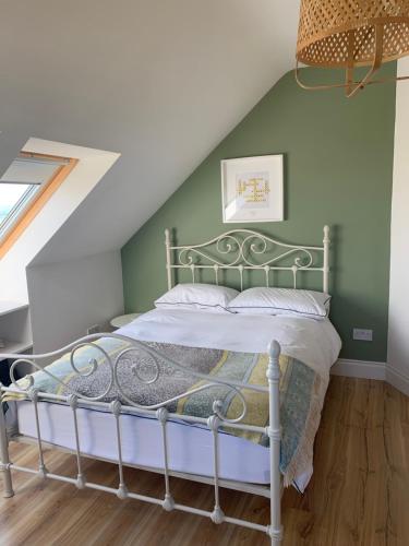 Cama en habitación con pared verde en Broadhaven Bay View Private House, en Belmullet