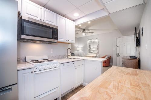 a kitchen with white cabinets and a counter top at Biscayne Suites in Ocean City