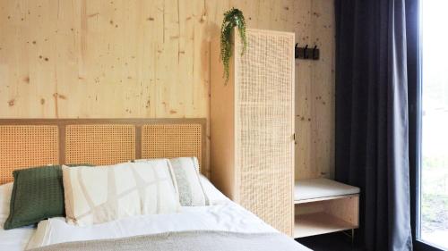 a bedroom with a bed with a plant on the wall at Hike & Bike Hotel in Noordwolde