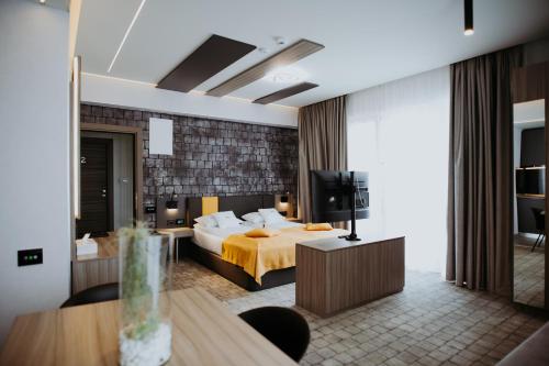 a hotel room with a bed and a television at Hotel Epic Centrum in Cisnădie