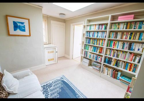 a living room with two book shelves filled with books at Benson House - Rye Town Centre, East Sussex in Rye