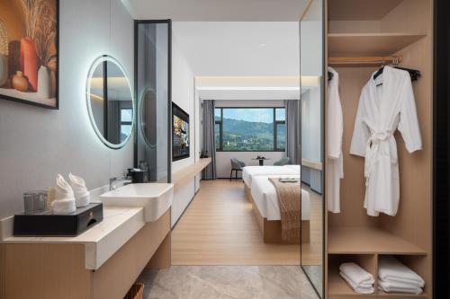 un bagno con lavandino e specchio di 隽雅酒店芙蓉镇景区点 a Wang-ts'un