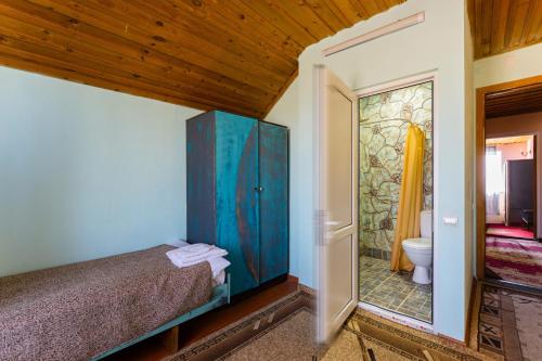 a bedroom with a bed and a bathroom with a mirror at The Forgotten Kingdom in Lchashen