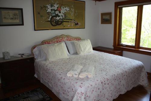 a bedroom with a bed with two slippers on it at Honey Maple Grove BnB in Bedford