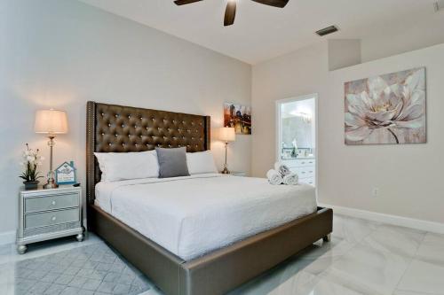 a bedroom with a large bed and a ceiling fan at The Pool House - Private, Heated Pool in Elwood Park