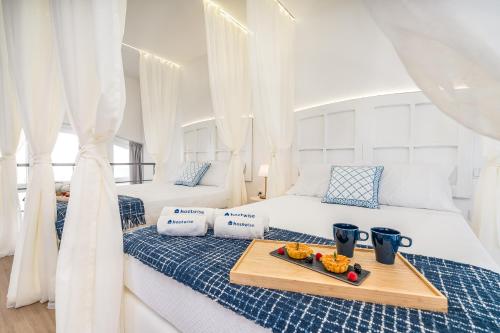 two beds in a room with a tray of food on it at Host Wise - Elegant Loft with Historic Charm & Terrace in Portel
