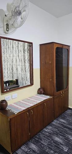 Un armario de madera con un espejo y un ventilador. en Travelers Rest, en Wadi Musa