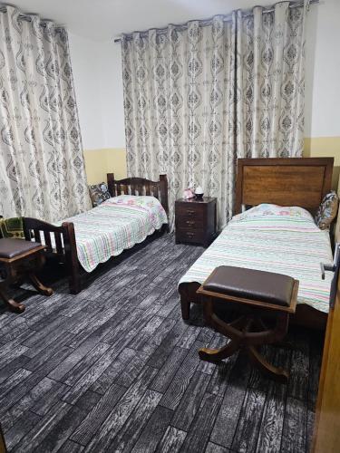 Un dormitorio con dos camas y una mesa y sillas. en Travelers Rest, en Wadi Musa