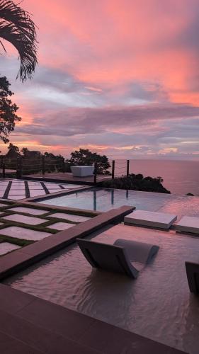 a pool of water with a sunset in the background at Silk Cotton Cottages in Parrot Hall