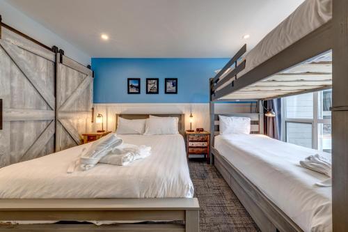 惠斯勒Greystone Lodge 329 Ski-in Out的一间蓝色墙壁的房间里有两张床