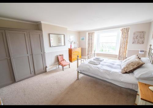 a bedroom with a bed and a window and a chair at Benson House - Rye Town Centre, East Sussex in Rye