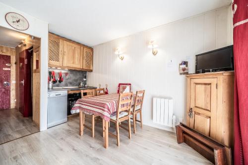 une cuisine et une salle à manger avec une table et des chaises dans l'établissement Les Pralyssimes 462, à Taninges
