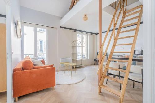 un salon avec une échelle et un canapé dans l'établissement Appartement Mezzanine proche Atelier des lumières, à Paris