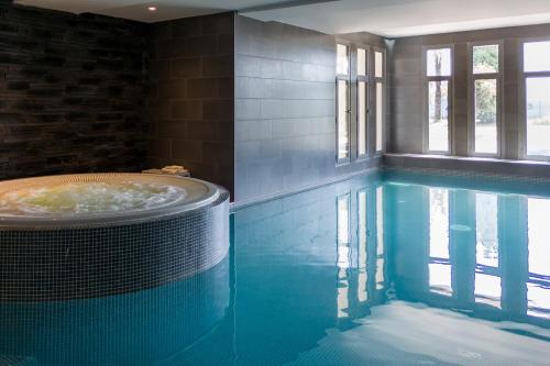 a large swimming pool with a tub in a house at Nemea Appart Hotel Nice Arenas Aéroport in Nice