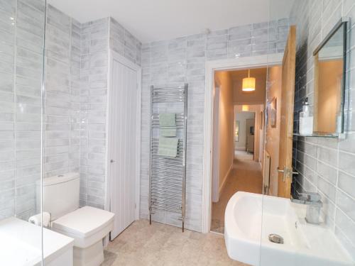 a bathroom with a toilet and a sink and a tub at Alfreton Cottage in Alfreton