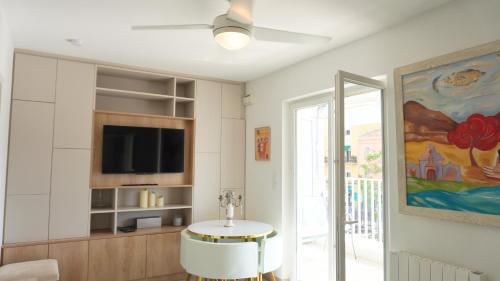 un salon avec une table et une télévision dans l'établissement Proche Palais Des Festivals - Croisette,Studio Bella - Palmazur Vacances, à Cannes