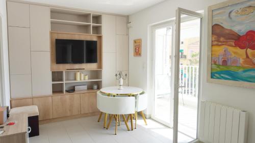 un salon avec une table et une télévision dans l'établissement Proche Palais Des Festivals - Croisette,Studio Bella - Palmazur Vacances, à Cannes