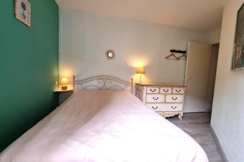 une chambre avec un lit blanc et un mur vert dans l'établissement Ô Saphir de Collioure - Proche plage - Garage - WIFI, à Collioure