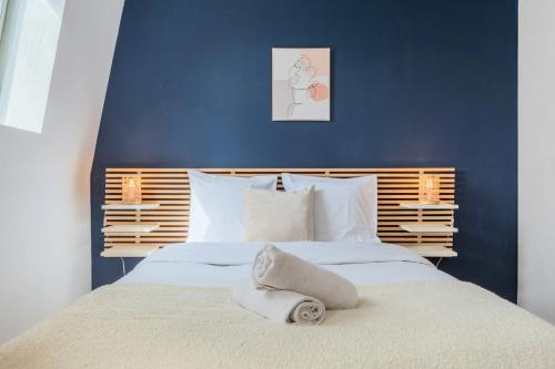 - une chambre bleue avec un lit et des serviettes dans l'établissement Studio équipé proche centre-ville et métro, à Tourcoing