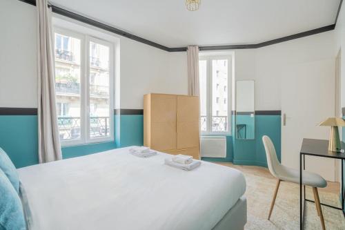 une chambre avec un lit et un bureau et deux fenêtres dans l'établissement Appartement Mezzanine cœur du 11ème arrondissement, à Paris