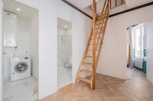 - une salle de bains avec une échelle à côté d'un lave-linge dans l'établissement Appartement Mezzanine cœur du 11ème arrondissement, à Paris