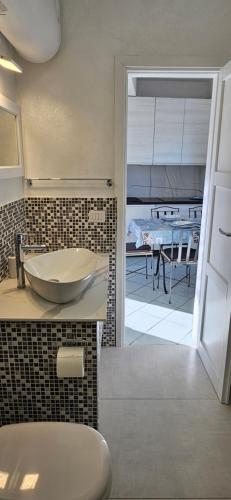 ein Badezimmer mit einem Waschbecken und einer Theke mit einem Tisch in der Unterkunft Casa prima fila con Vista Mare in Isola Rossa