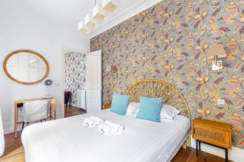 une chambre avec un lit blanc avec des oreillers bleus dans l'établissement GuestReady - Spacieux Appartement idéal pour 6, à Paris