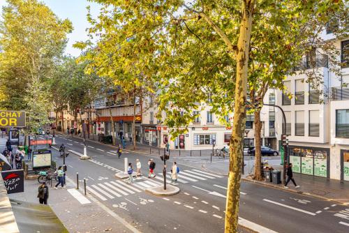 Une rue urbaine animée avec des gens qui traversent la rue dans l'établissement GuestReady - Spacieux Appartement idéal pour 6, à Paris